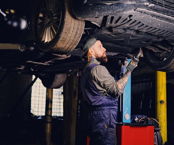 bearded-mechanic-working-with-the-cars-chassis-in-small.jpg